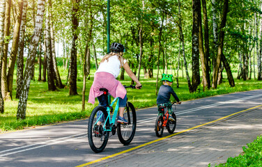 Fototapeta premium A woman and her son ride bicycles in the park