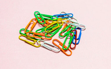 Office paper clips isolated on colored background. Pink, red, blue, green, orange colorful Plastic paperclips documents staple attach tools.