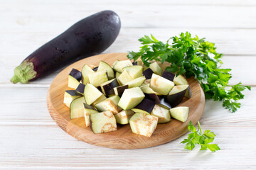 Chopped eggplant and knife on cutting board on table