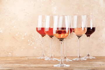 Rose wine glasses on the beige table. Rosado, rosato or blush wine tasting concept, negative space