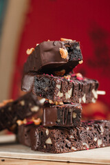 many delicious chocolate brownies with nuts in chocolate on a stick in the summer in a cafe