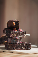 many delicious chocolate brownies with nuts in chocolate on a stick in the summer in a cafe