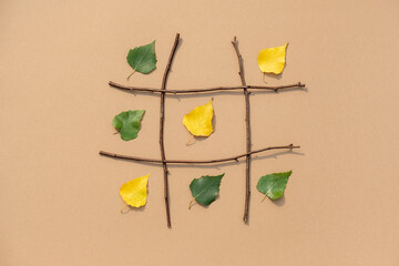 Creative autumn concept. Tic-tac-toe, noughts and crosses between summer and autumn. Green and...