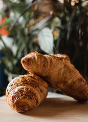 French croissants in a summer cafe on a wooden tray next to books