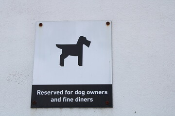 Silhouette dog sign parking reserved for dog owners and fine diners on white textured wall with...