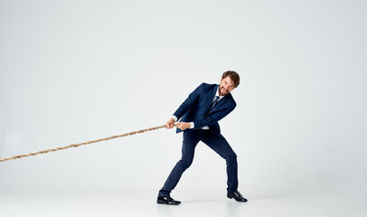 a man in a suit pulling a rope office manager teamwork