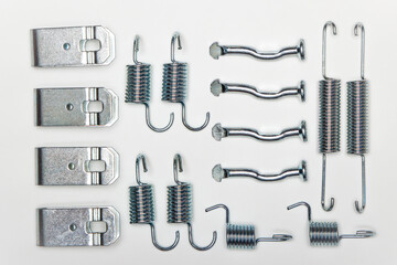 A set of metal components is laid out on the table, parts for car repair. A set of spare parts for...