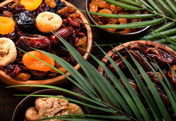 Dried fruits bowl. Healthy food snack: sun dried organic mix of apricots, figs, raisins, dates and other on wooden table, top view