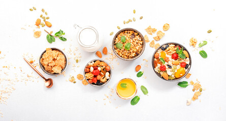 Muesli bowl and ingredients for healthy breakfast. Granola, nuts, dried fruits, flakes, honey and...