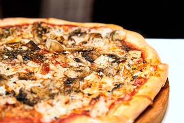 Fresh pizza with bacon, mushrooms and cheese on a light background. Close-up, selective focus