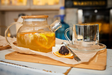 Sea buckthorn tea in a transparent glass teapot. Close-up, selective focus