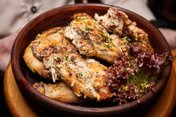 Baked chicken in a ceramic bowl. Close-up, selective focus