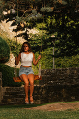 Gorgeous blonde woman enjoying on the swing during golden hour