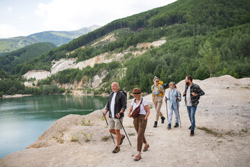 Happy multigeneration family on hiking trip on summer holiday, walking.