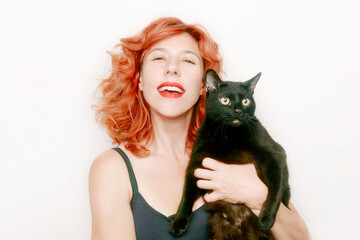 portrait of red-haired woman with large black cat