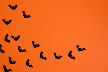Fototapeta na wymiar Black bats on an orange background. Copy space. Background for design .