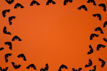 Black bats on an orange background. Copy space. Background for design .