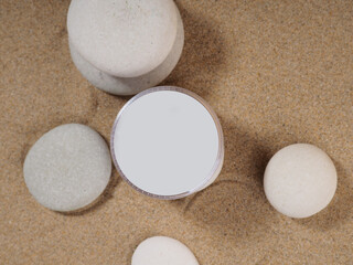 bottles and cans with cosmetics, on zen stones and sand, mockup for design