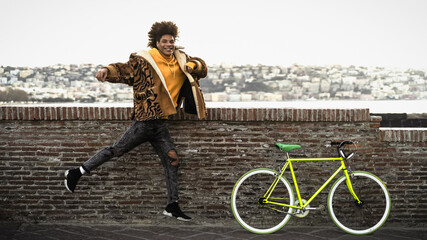 Happy African man having fun with bike in the city - Youth millennial generation lifestyle concept