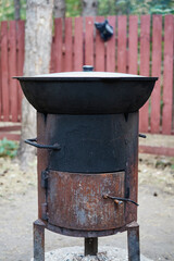 Obraz premium stove for a cast-iron cauldron for pilaf in nature