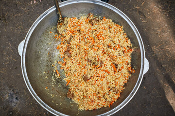 pilaf in a cast-iron cauldron cooked in nature top view