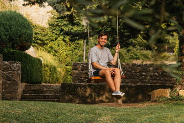 Young boy enjoying on the swing during golden hour