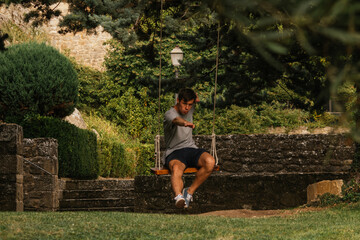 Young boy enjoying on the swing during golden hour