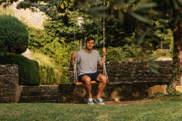 Young boy enjoying on the swing during golden hour