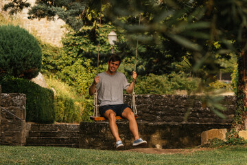 Young boy enjoying on the swing during golden hour