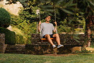 Young boy enjoying on the swing during golden hour
