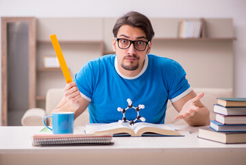 Young male student physicist studying molecular model