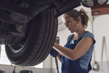 Female mechanic doing a wheel replacement
