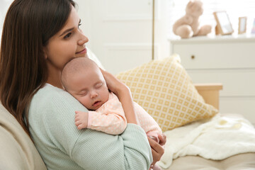 Fototapeta na wymiar Mother holding her sleeping baby at home