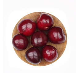 Cherry fruits in wooden cup isolated on white background. Top view