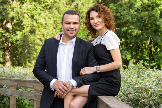 Portrait of a couple in love. A Middle Eastern man in a business suit with his curly-haired wife in a black dress