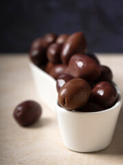 black olives in a ceramic plate for snacks, dark background