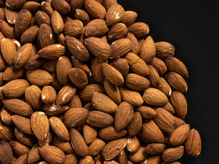 almond in black plate on wood table for food and health  concept