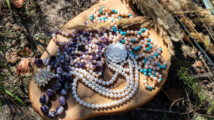 Beautiful amethyst,turquoise  and iridescent pearl necklaces  on a wooden surface. Jewelry from...