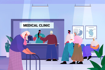 senior patients visiting medical clinic office female receptionist giving information for old people at reception desk