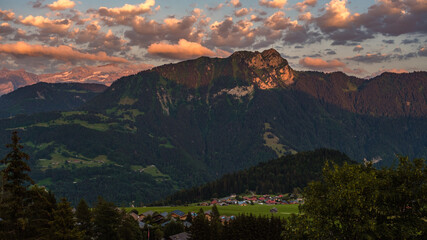 Spectacular Alpine view of a sunset with orange clouds over the Alps near swiss municipality of...