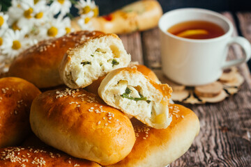 Pies with onions and eggs. Russian national dish. Delicious pies on a wooden table 