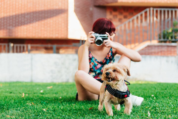 Professional photographer taking pictures of her dog outdoors with her camera