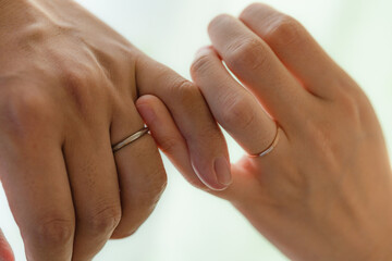 結婚指輪を付けて小指を絡める