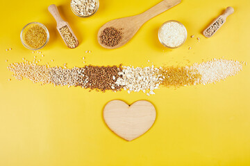 Flat lay of set of heap various grains and cereals on yellow background