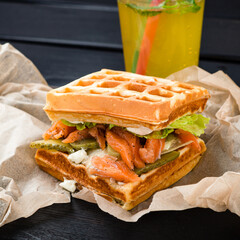 Belgian waffle with salmon on wood table. Keto Breakfast variation.
