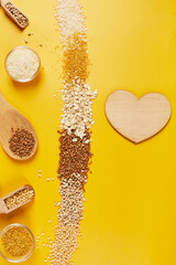 Flat lay of set of heap various grains and cereals on yellow background