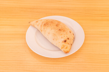 Popular recipe for Italian calzone stuffed with ham and mushrooms cooked in a stone oven