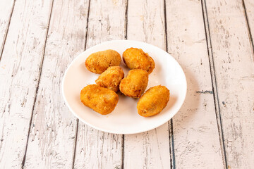 Typical Spanish tapa of croquettes stuffed with béchamel and Iberian ham tacos on a white plate