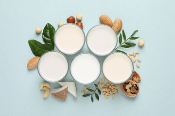 Fototapeta na wymiar Vegan milk and different nuts on light background, flat lay
