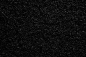Black astrakhan background from warm woolen fabric